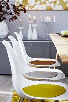Kunststoffstühle mit farbigen Sitzkissen an Esstisch