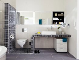 Wachtisch mit Mosaikfliesen und Toilette im Badezimmer