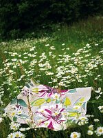 A floral patterned blanket lying on flowery meadow