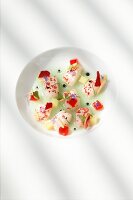 Raw marinated prawns, rha barber, strawberry jelly and almonds on plate