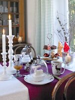 Table with tiered stand, lit candles and dishes