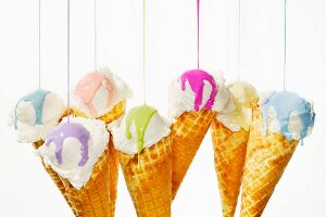 Various different colours of nail polish being poured onto ice cream cones