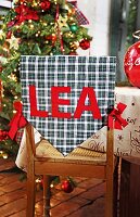 "Plaid backrest cushion with letter ""Lea"" on wooden chair "