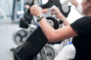 Woman holding crank handles and exercising, blurred motion