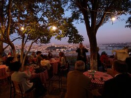 People sitting at restaurant in Bosphorus, overlooking city, Istanbul, Turkey