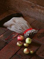 Fabric bag with faux fur edge and satin ribbon with apples by side