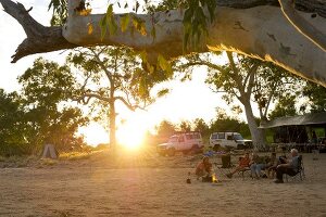People sitting around camp fire in Ormiston Creek, Alice Springs, Australia