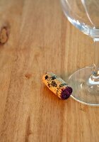 Close-up of wineglass with cork on wooden table
