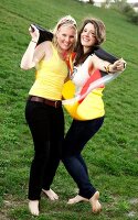 Portrait of two beautiful woman holding Germany flag behind them