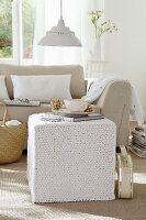 A knitted pouffe in a living room decorated in light tones