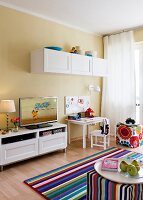TV, magnetic board, TV bench, painting table and striped carpet in living room