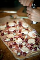 Tart with goat cheese, red onions, grapes and salt on wooden platform