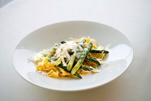 Pasta with green asparagus and parmesan on plate