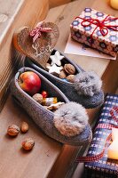 Felt slippers filled with nuts, apples and biscuits