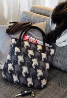 Grey and black bag made of felt and fur on sofa