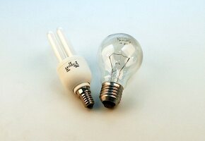 Two different energy saving bulbs on white background