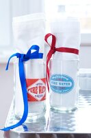 Napkins rolled in blue and red ribbons in glass