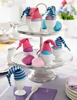 Easter eggs with little hats on a cake stand