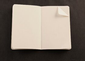 Notizbuch mit Eselsohr, schwarzer Hintergrund