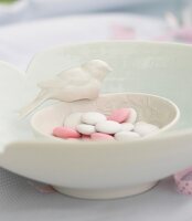 Close-up of porcelain bowl with bird and filled by chocolate beans