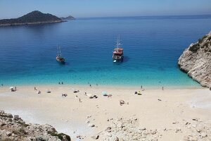 People and two ships at Kaputas beach in Turkey