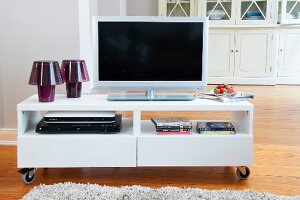 TV on TV cabinet with wheels on wooden floor