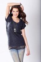 Portrait of pretty woman with long brown hair wearing blue blouse, jeans and long chain