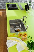 Tomatoes washes with water pouring from tap in clean kitchen sink