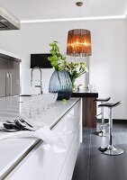Dining area in kitchen with stools and flower vase