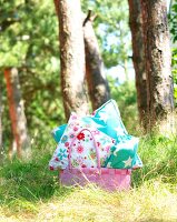 Colourful pillows with pink wicker basket under tree in garden