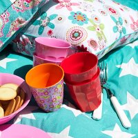 Rice cups with cushions and folk on blue star motif cloth