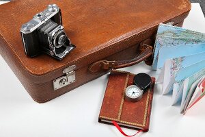 Diary, camera, briefcase and map for travel on white background