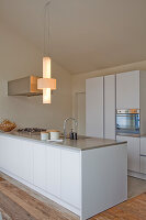 Modern kitchen with cooking island with white fronts