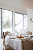 Elegant breakfast table with bread rolls and candlelight in a bright room