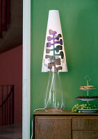 Table lamp with patterned shade on a wooden chest of drawers