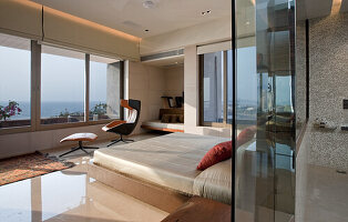 Modern bedroom with designer furniture and panoramic window with sea view