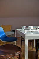 Dining area with blue chair and white table with crockery