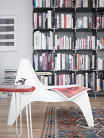 White chair in front of bookshelf in a living room