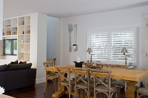 Bright living room with large wooden dining table and black sofa