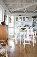 Bright dining area with white chairs and country-style wooden furniture