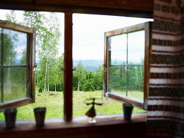 Geöffnete Fenster mit Blick auf grüne Landschaft