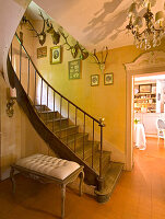 Vintage-style entrance area with spiral staircase and antlers