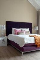 Purple bed with white bed linen and accent pillows in the loft