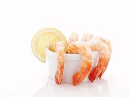 Shrimps mit Dip in einem Schälchen mit Zitronenscheibe
