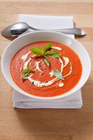Cream of tomato soup garnished with creme fraiche and basil