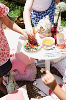 Children's hands taking Smarties from a dish