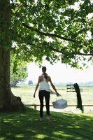 Woman with basket below tree