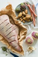 Lamb with Slits Cut on Butchers Paper and Assorted Vegetables For Roasting; From Above