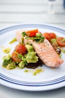Poached salmon fillet with tomato and avocado salad on a hash brown