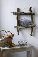 Woven bread basket and rustic driftwood picture frame on a white wall